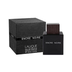 Lalique Encre Noire Eau de Toilette perfume bottle with a dark wood-grain cap next to its textured black packaging box, on a white background.