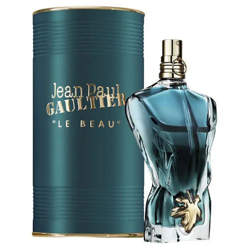 Jean Paul Gaultier Le Beau Eau de Toilette bottle with a sculpted glass body and gold cap, shown next to its metallic teal cylindrical packaging box with gold lettering.