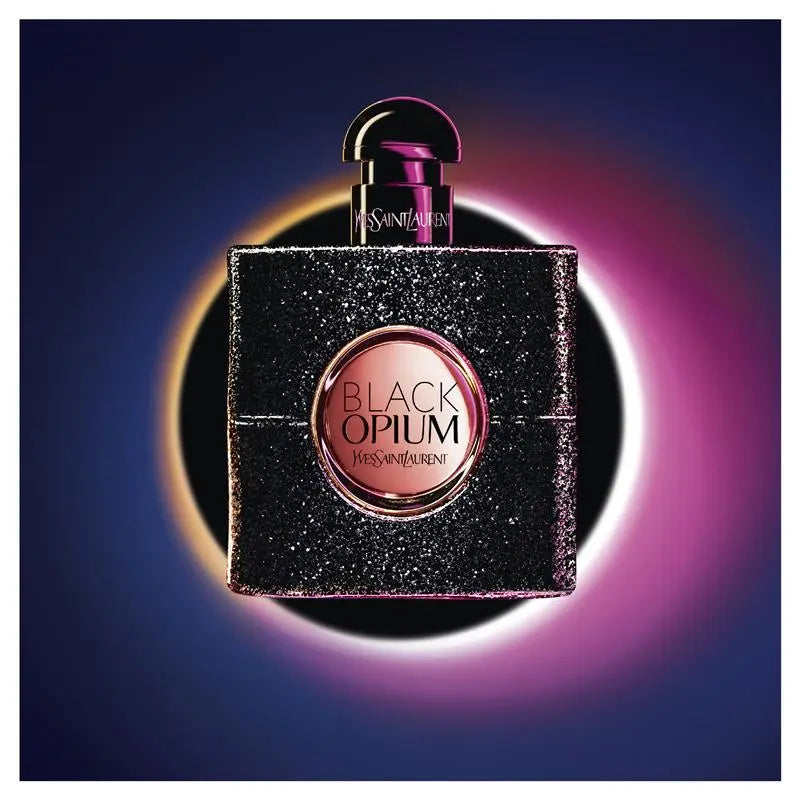 Yves Saint Laurent Black Opium perfume bottle on a dark blue and pink gradient background